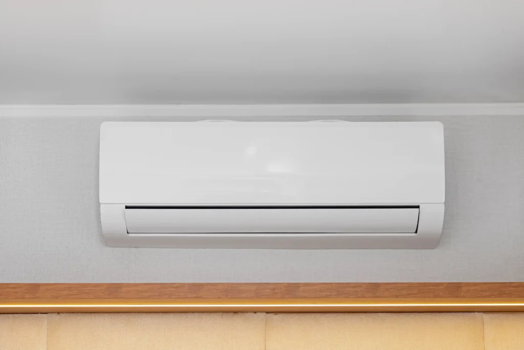 ductless ac 3 wall-mounted white air conditioning unit installed near the ceiling with wooden trim below, designed for efficient indoor cooling